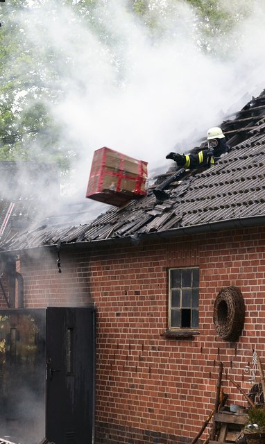 Ein Feuerwehrmann unter Atemschutz räumte die 
Scheune von innen leer