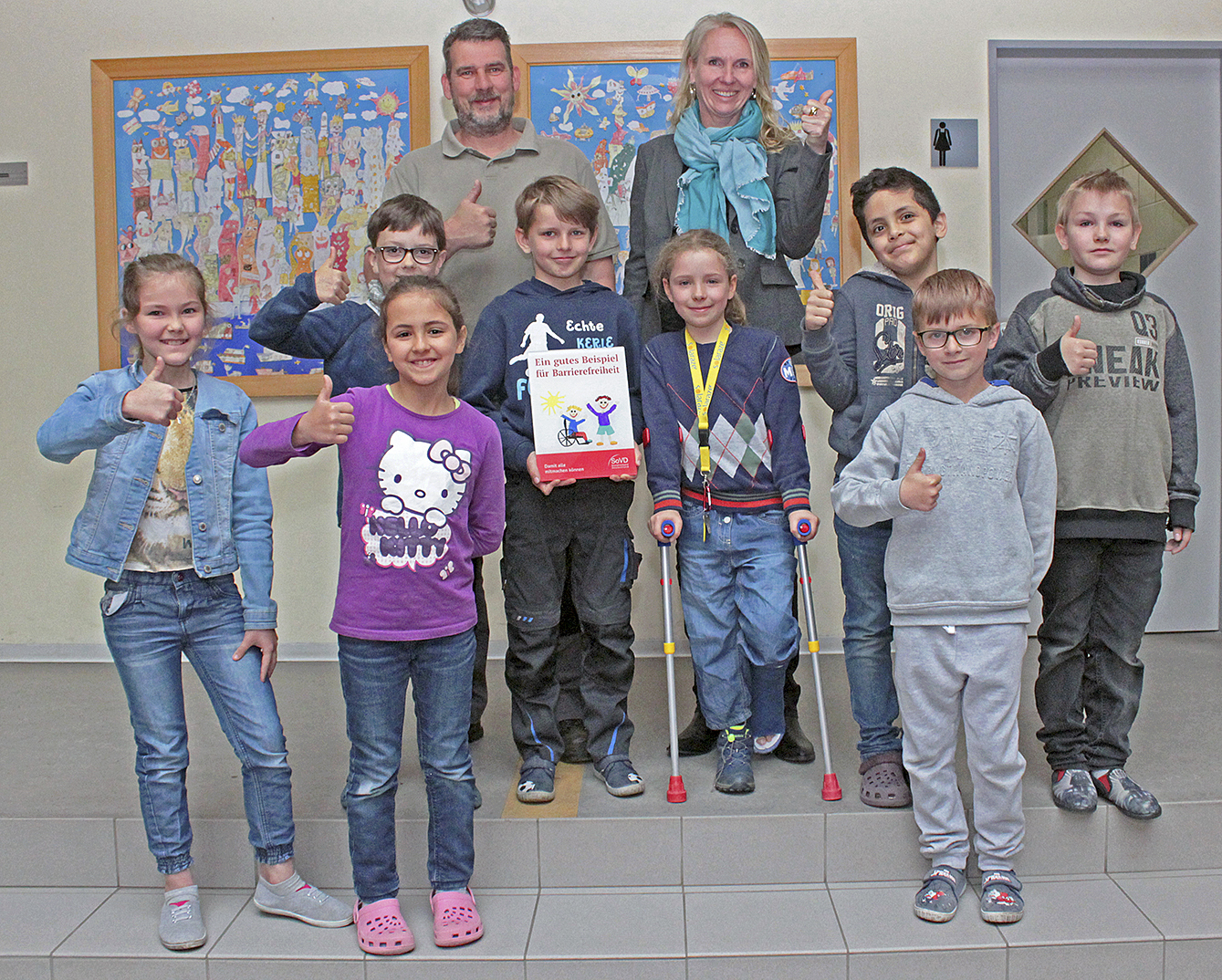 Hausmeister Andreas Löhden und Schulleiterin Sabine Folster freuen sich gemeinsam mit den Kindern der Klasse 2c über die Auszeichnung Foto: jab