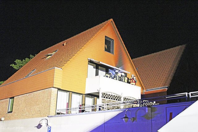 Die Flammen hatten auch die Hausfassade beschädigt: die Feuerwehr auf dem in Brand geratenen Balkon Foto: ce