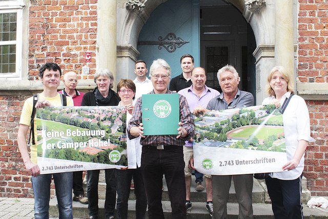 Vertreter der BI postierten sich vor dem Rathaus mit dem Ordner, der die Unterschriftenlisten enthält Foto: jab