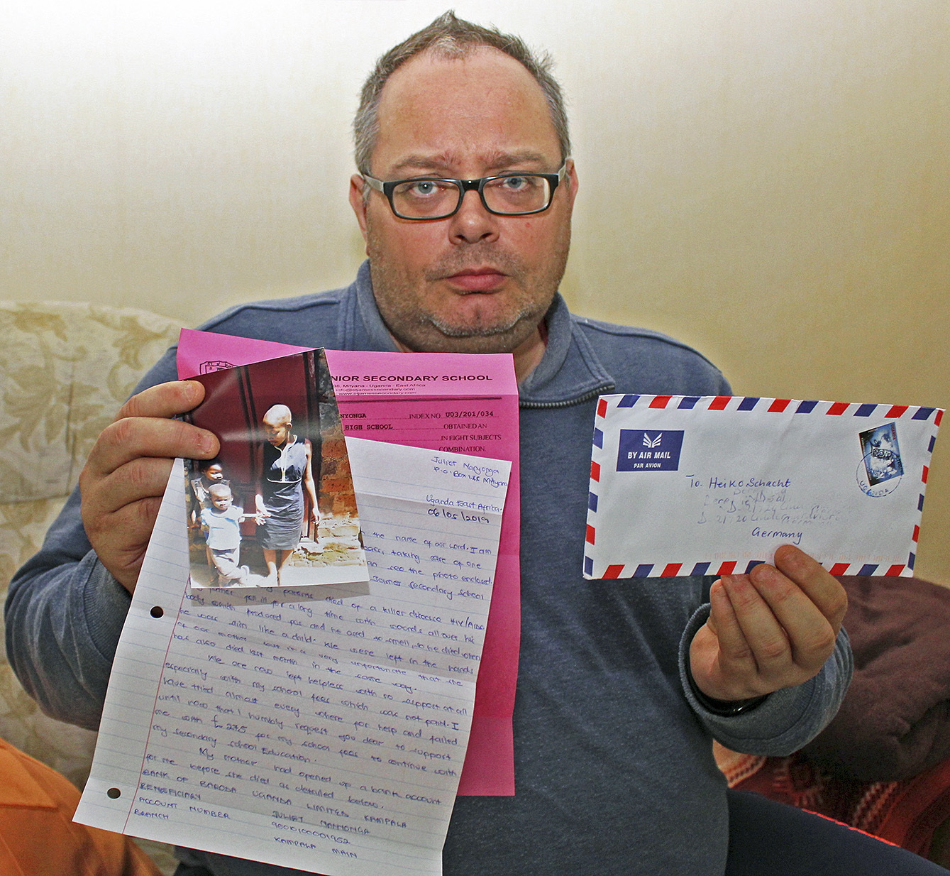 Ein handgeschriebener Brief, ein hochwertiges Foto und die Bescheinigung einer Schule: Heiko Schacht mit dem dubiosen Schreiben aus Uganda