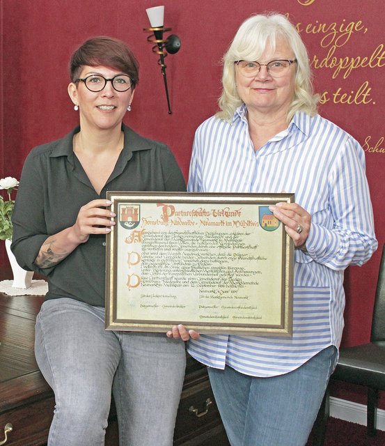 Vanessa Heider (li.) und Eveline Bansemer präsentieren die Urkunde über die Städtepartnerschaft Foto: jab