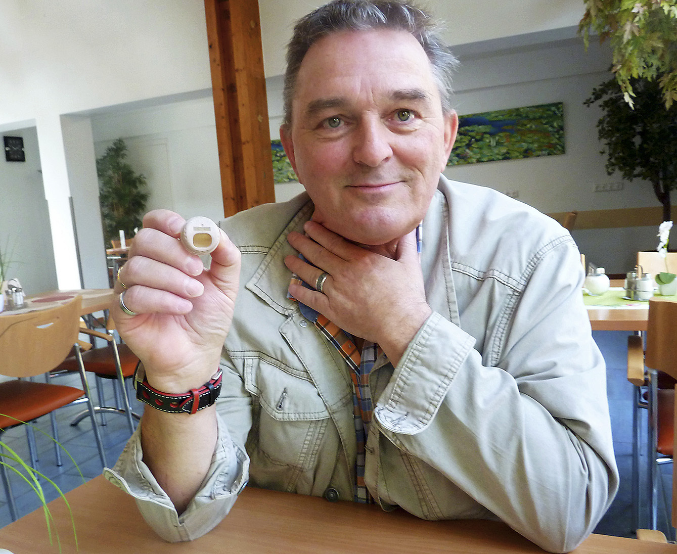 Ralf Westmeier zeigt die kleine Kunststoffkappe, die er im Hals trägt und die seine Atemorgane schützt