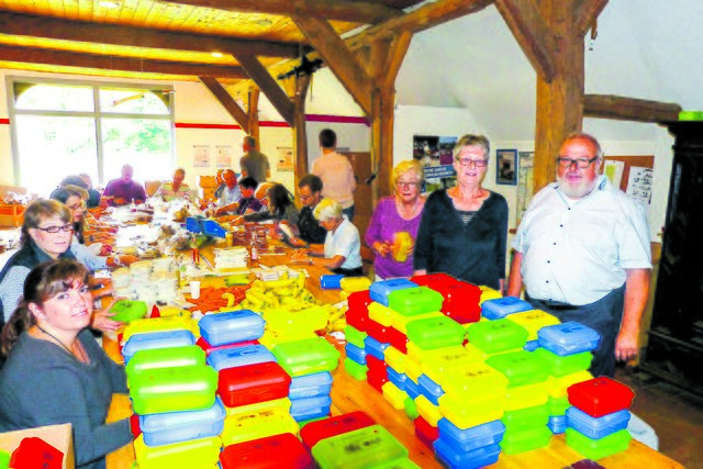2.100 Brotdosen wurden am Sonntag auf dem Museumsbauernhof Wennerstorf von Hand befüllt, dabei wurden Rolf (v. re.) und Giesela Wiese von vielen Helfern unterstützt | Foto: Weede