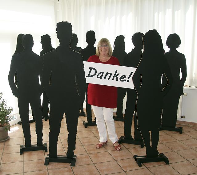 Susanne Dinter steht inmitten von Silhouetten, die die ehrenamtlichen Engagierten repräsentieren sollen | Foto: Dinter