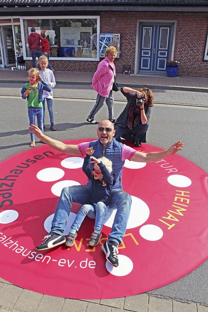 Spektakulärer Schauplatz: Fotografin Christina Opeldus (hi.) lichtete auf der Eyendorfer Straße in einem XXL-Logo des Vereins "Salzhausen e.V." auch Heiko Riebesell und Tochter Elise ab | Foto: ce