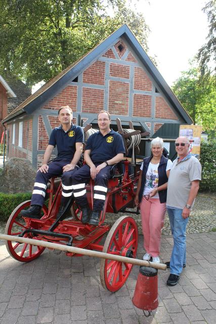 Historische Feuerwehr-Ausstattung: Sven Plate (v. li.) und Lars Schulenburg nahmen Platz auf dem alten Handdruck-Spritzenwagen, den die Besucher Ute und Hartmut Overbeck bestaunten | Foto: ce