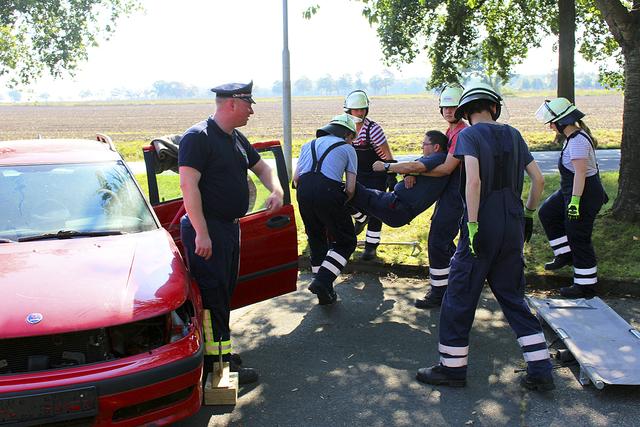Während ihrer Truppmannausbildung üben Feuerwehrleute die Rettung aus einem Pkw