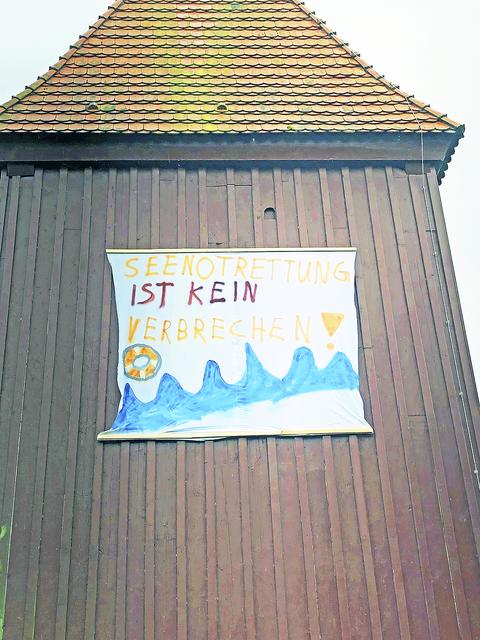 Berührender Blickfang: das mahnende Plakat am Kirchturm