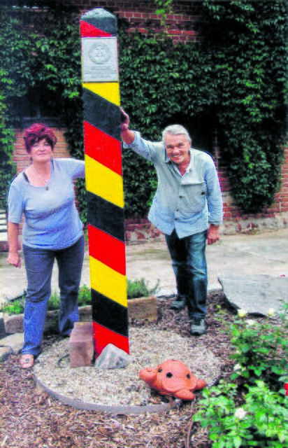 Birgit und Friedrich Meyer stehen vor einem Grenzstein, den ein befreundetes Paar in Hohengrieben (Sachsen-Anhalt) aufgestellt hat