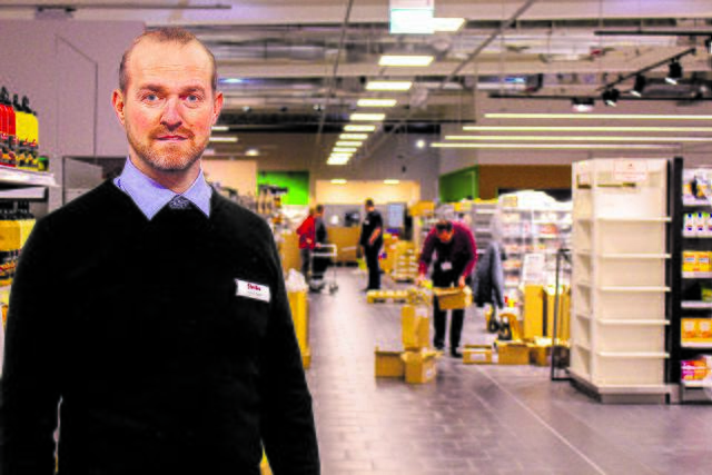 Heiko Tank steht im neuen Warenhaus, während um ihn herum eifrig gearbeitet wird