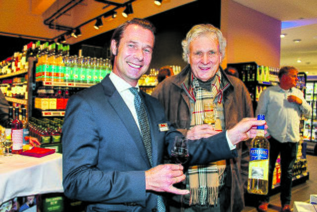  "famila"- Geschäftsführer Christian Lahrtz (li.) zeigt Bernd Jost (Naturbühne Jesteburg) den neuen "Jesteburg Sekt"