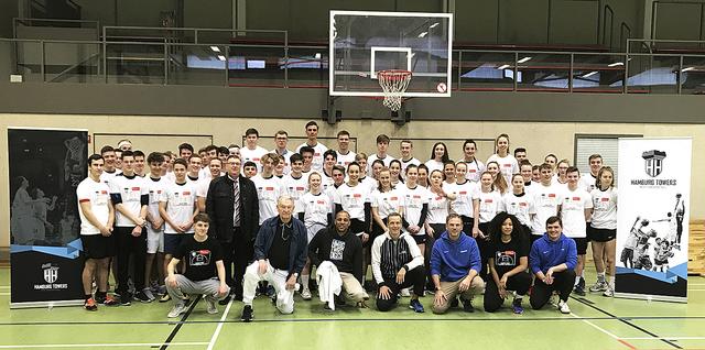 „Tag des Basketballs“ am GAK: 60 Schüler und Schulleiter Armin May (vorne stehend) waren begeistert vom Besuch der Towers und ihrem Boss Marvin Willoughby (vorne mittig sitzend)