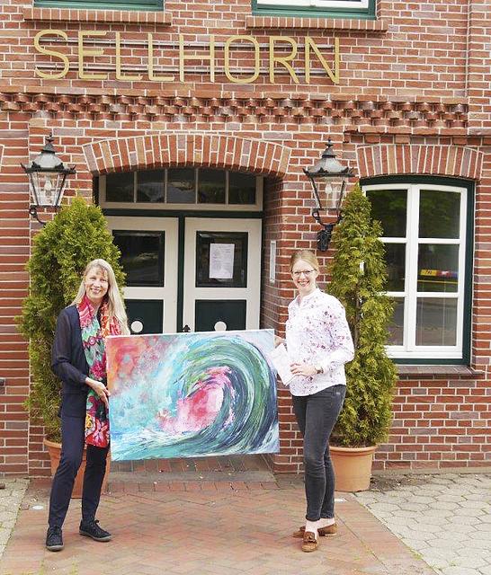 Künstlerin Kerstin Hirsch (li.) und und Nele Landschof vom Hotel Sellhorn präsentieren das Siegerbild "Die Welle" | Foto: HeideKultour