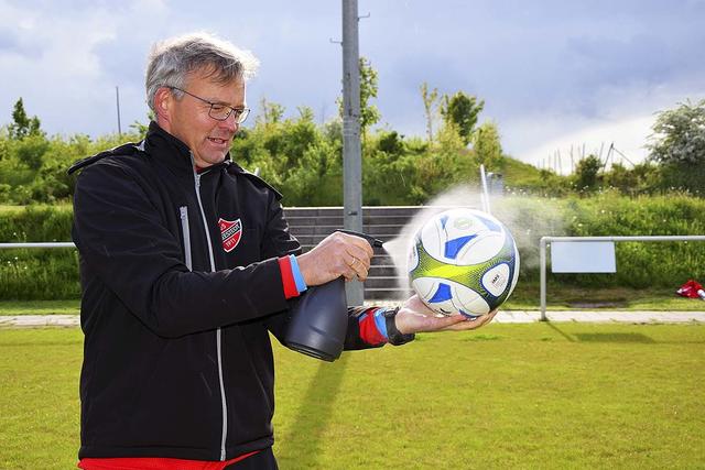 Trainer Michael Sandgaard desinfiziert jeden Fußball, bevor die Jugendlichen mit ihm spielen