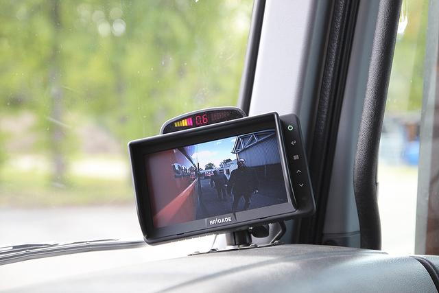 Über einen Monitor sieht der Fahrer, dass sich Personen (hier Josef Nießen und Jochen Brück) neben seinem Fahrzeug befinden