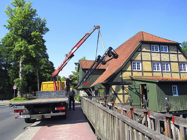 Die mechanische Harke zur Reinigung des Treibgut-Rechens 
schwebt am Kran vor dem Mühlenmuseum Moisburg  | Foto: FLMK