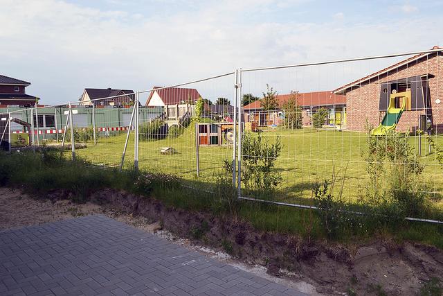 Blick von der Kita zur Krippe: Das 1.600 Quadratmeter große Außenspielgelände wird noch angeglichen, wenn die Container (links) weg sind | Foto: bim