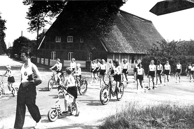 Mitglieder des TV Meckelfeld ziehen im Jahr 1948 in Sportkleidung durch den Ort