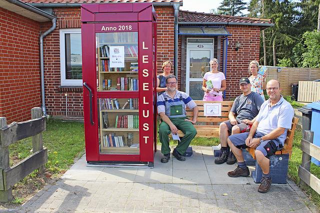 An der Bücherzelle mit Sitzbank: (hi., v. li.) Katharina Krieger, Ina Dieck und Angela Cordes von den "Schmökerschnepfen" sowie (vorne, v. li.) Ralf-Peter Dieck, Stephan Zumsande und Rolf Heuschkel von der Montagetruppe