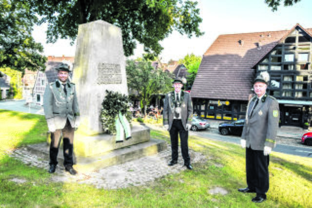 Erster stellvertretender Vorsitzender Timo Röntsch (v. li.), Schützenkönig Sören Sahling und Adjutant Georg Kant legten am Ehrenmal an der Kirchstraße einen Kranz nieder