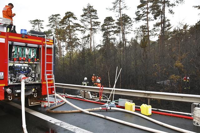 Feuerwehrleute aus dem Landkreis Harburg nahe der Einsatzstelle an der A7