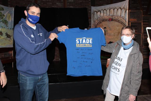 Trainer Joan Rallo Fernández überreicht Barbara Reed als symbolische Spende ein T-Shirt des Teams