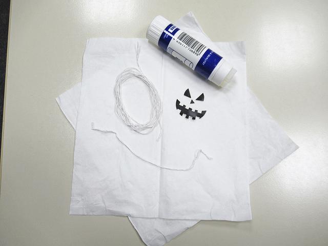 Material: 2 Taschentücher, ca. 40 cm Schnur (Wolle/Nähgarn), etwas schwarzes Papier, Klebestift (+ eine Schere).