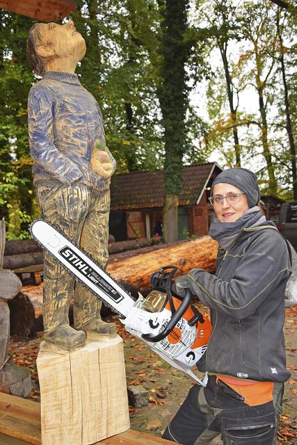 Kettensägekünstlerin Sylvia Itzen neben ihrer Skulptur "Himmelsgucker", gartengerecht mit einem Apfel bestückt | Foto: ts