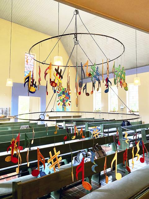 Bemalte Noten aus Holz hängen an einem Kranz in der Nikodemuskirche