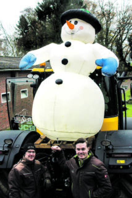 Jan-Peter Kahnenbley (li) und Frederic Wübbe schmücken einen Traktor für den Weihnachtskorso in Seevetal | Foto: Wübbe