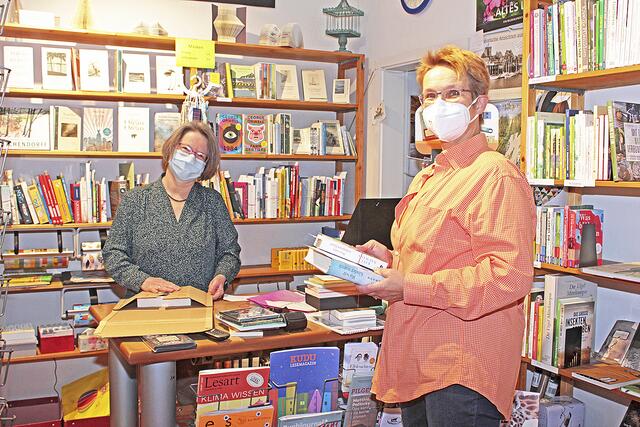 Sabine Gahde (li.) und ihre Angestellte Barbara Burmeister von der Contor Buchhandlung              verpacken die Bücher für den Versand und die Abholstation vor der Ladentür | Foto: jab