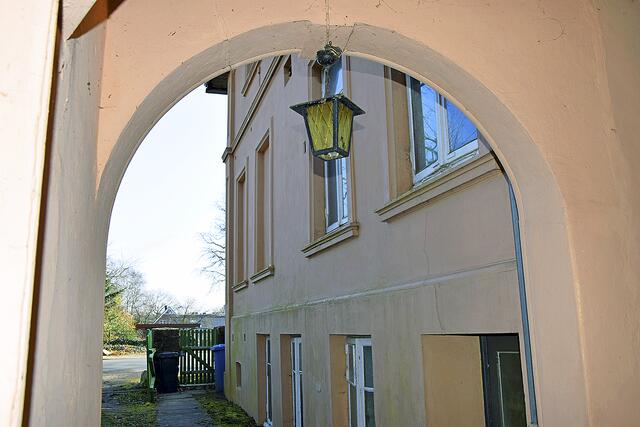 Blick durch einen weiten Torbogen auf die fensterreiche 
Gebäudefassade und die Bahnhofstraße | Foto: ts