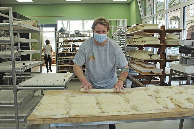 Sascha Schäfer bereitet die Baguettes für den Ofen 
vor - durch die großen Fenster können Interessierte von außen zuschauen   Fotos: wd
