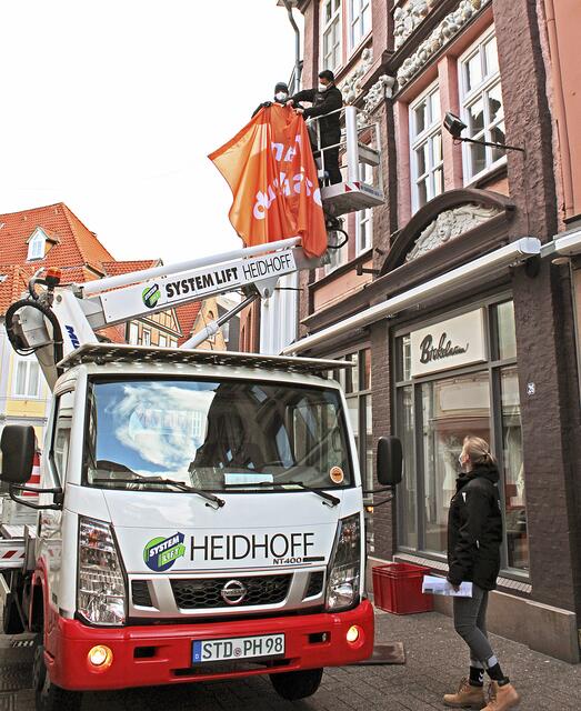 Mit einer Hebebühne werden die Banner angebracht