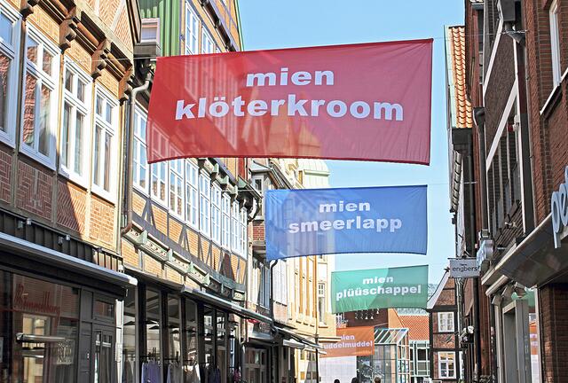 Über den Köpfen der Passanten hängen die Banner bis in den Sommer in den Gassen der Stader Altstadt