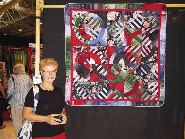 Die Künstlerin bei dem International Festival of Quilts in Birmingham 2011 vor der Decke, die sie für die Olympiade 2012 gespendet hat