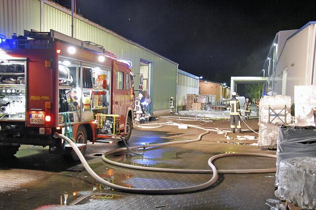 Am Einsatzort: Feuerwehrleute vor der Lager- und Produktionshalle des Kunststoffwerks in Garstedt