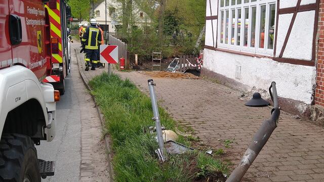 Ein Laternenpfahl, die Hausmauer und ein Absperrgitter wurden bei dem Unfall beschädigt