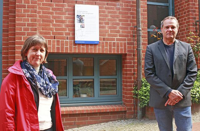 Dr. Christina Deggim und Dr. Andreas Schäfer vor der Informationstafel zu den Stolpersteinen in Stade, die sich im Hagedorn 6 befindet