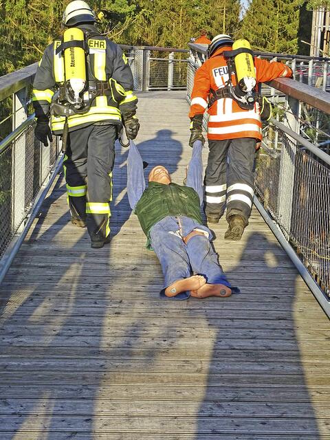 Zwei Feuerwehrleute ziehen einen 75 Kilogramm schweren Dummy