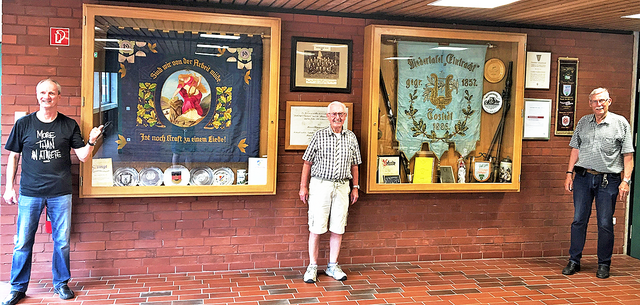 Mit den Vereinsfahnen in der Turnhalle Poststraße (v. li.): Vorsitzender Lothar Schlaack, Notenwart Wilfried König und der zweite Vorsitzende Klaus-Henning Becker