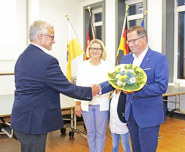 Der noch amtierende Landrat Michael Roesberg überreicht seinem Nachfolger Glückwünsche und einen Blumenstrauß | Foto: jab