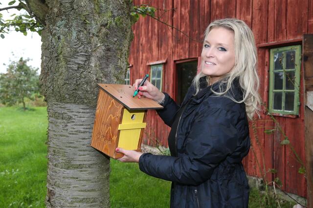 Rixa Herzogin von Oldenburg signiert einen Niskasten, den jedes Team auf dem Harmshof bekam