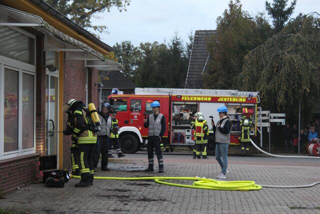 Die Feuerwehr versucht die Tür zur Karateschule zu öffnen. Bei einem richtigen Einsatz würde notfalls das Fenster eingeschlagen, doch bei der Übung haben die Retter die Auflage, Tür und Fenster heil zu lassen