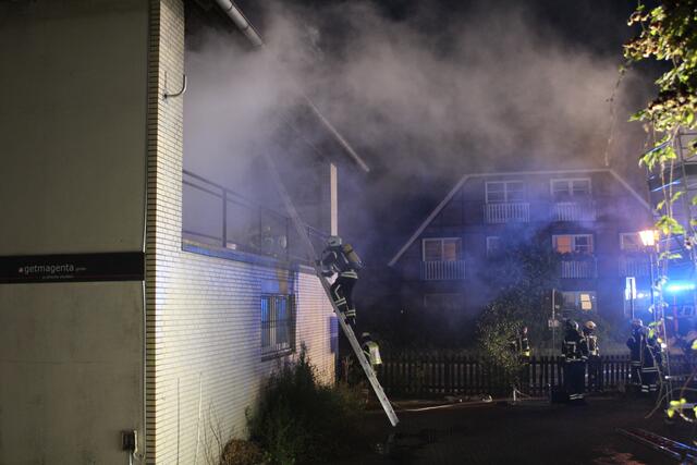 Unter Atemschutz versuchen die Feuerwehrleute, den Brand vom ersten Stock aus zu löschen