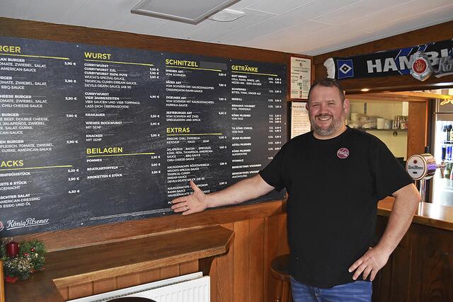 Björn Wucherpfennig zeigt auf die umfangreiche Speisekarte, auf der jeder Gast sein Lieblingsgericht findet | Foto: Axel-Holger Haase