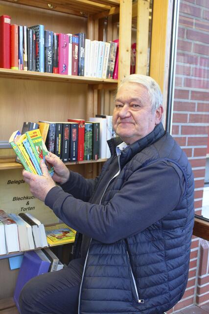 Reiner Klintworth sortiert Bücher ins Regal