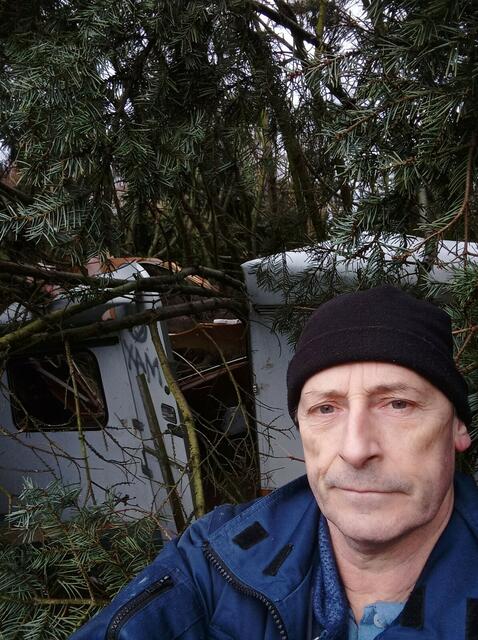 Vor dem zerstörten Wohnwagen: Besitzer Rainer Peters, der mit dem Schrecken davonkam | Foto: Rainer Peters