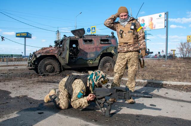Ukrainische Soldaten verteidigen eine Kreuzung. Im Hintergrund ein zerstörtes russisches Militärfahrzeug (bei Charkiw) | Foto: Unian Photobank/Andreas Marienko